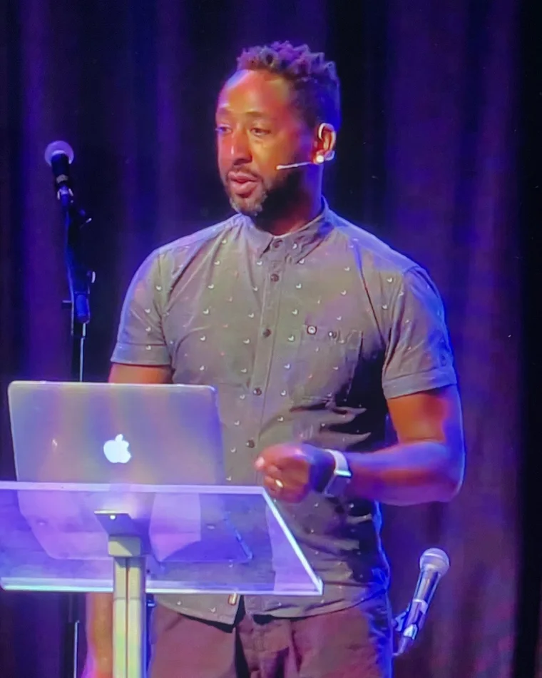 Eugene Dunkley speaking on stage